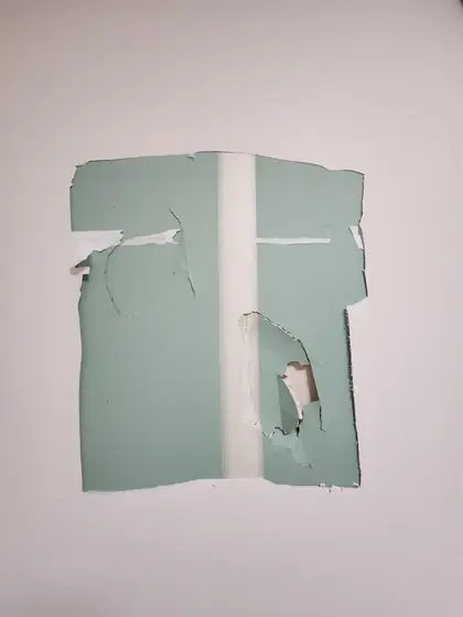 석고보드 구멍 보수 — 벽지를 걷은 초록색 석고보드